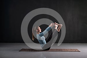 Girl practices yoga,doing n boat pose, Navasana, exercise for abs.