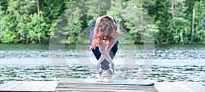 girl practicing yoga in the nature on the lake. Female happiness. Concept of healthy life and natural balance. Landscape