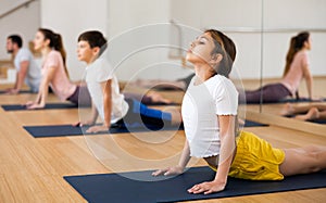 Girl practicing yoga at studio with family