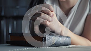 Girl praying indoors at bedtime on bible. religion concept evening prayer woman brunette hands on bible praying by