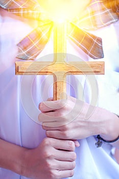 girl praying to God with a cross