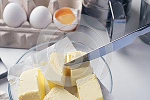 Girl preparing cookies in the kitchen, cutting butter, close-up. A woman prepares dough for delicious pastries. Step-by-step