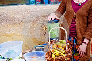 Girl preparing raw food smoothie from healthy natural ingredients.