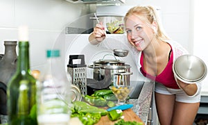 Girl preparing soup in cooking pot