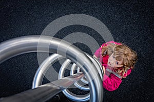 Girl preparing to climb metal swirl