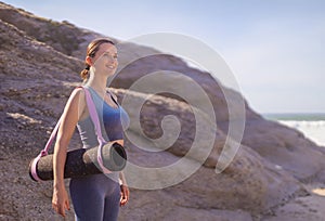 A girl is preparing to practice outdoor yoga on the ocean. Calmness and relax. Background with ocean view and yoga