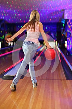 Girl preparing to throw of ball in bowling club