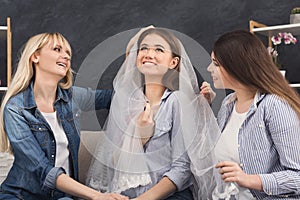 Girl preparing for wedding and showing bridal veil