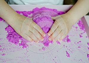 Girl preschooler sculpts kinesthetic sand photo