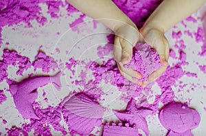 Kid`s hands with kinesthetic sand photo