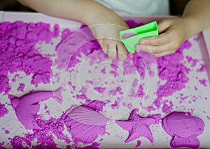 Kid`s hands with kinesthetic sand photo