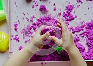 Kid`s hands with kinesthetic sand photo