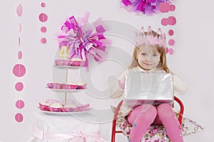 Girl with present at pink decoration birthday party