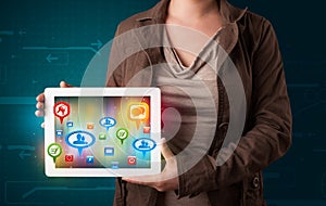 Girl presenting a tablet with colorful social icons and signs