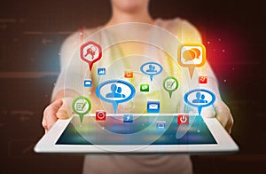 Girl presenting a tablet with colorful social icons and signs