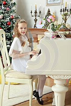 The girl presses the keys of the piano.