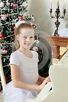 The girl presses the keys of the piano.