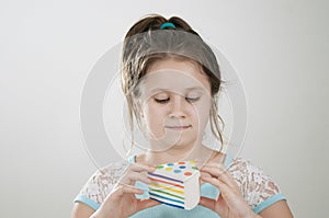 A girl pretending to eat a sguishy toy cake in her hand