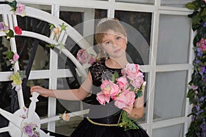 Girl princess in a black dress with a becket of flowers in her hands