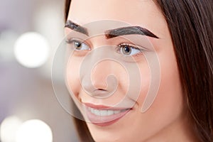 Girl during procedure of permanent make up of eyebrows.