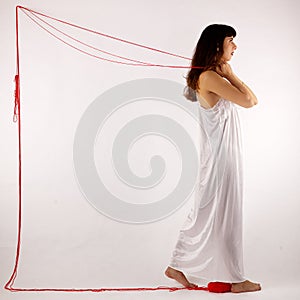 Girl profile white silk nightie lifting pulling red thread on white background