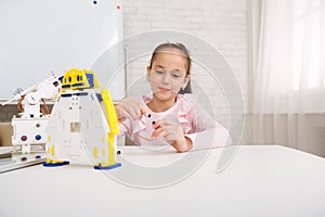 Girl programming robot, working with wires in class
