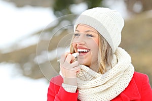 Girl protecting lips with lip balm in winter