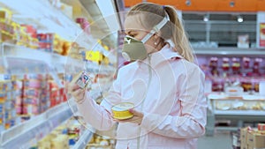 Girl in protective mask carefully selects products in supermarket, quarantine coronovirus security measures