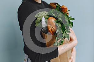 Girl in protective mask holds package with products