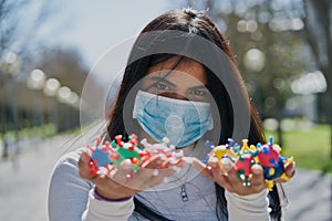 Girl with a protective mask to prevent infection and with virus models on her hands. Coronavirus concept