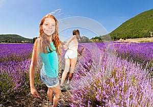 Girl pulling friend holding hand in lavender field