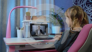 Girl pupil doing school homework with man teacher, using laptop computer at home, distance education