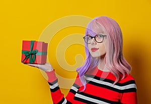 Girl with purple hair in red striped sweater with gift box