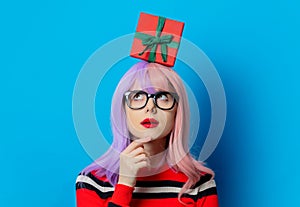 Girl with purple hair and red sweater hold gift box