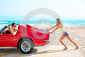 Girl pushing a broken car on the beach funny guy