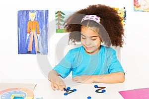 Girl puts blue coins learning to count