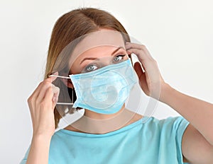 Girl puts a medical face mask for protection against infection. Healthcare and medical concept