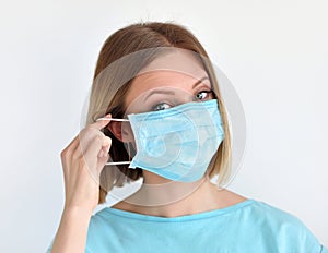 Girl puts a medical face mask for protection against infection. Healthcare and medical concept