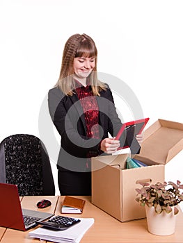 Girl puts a photo frame on desktop from box office