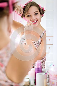 Girl putting curlers in hair