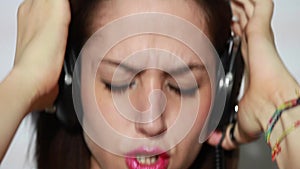 Girl putting headphones on, listening to music and singing