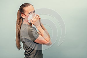 A girl is putting on a protective mask. Respiratory protection from coronavirus. Personal protective equipment for a