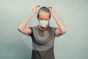 A girl is putting on a protective mask. Respiratory protection from coronavirus. Personal protective equipment for a