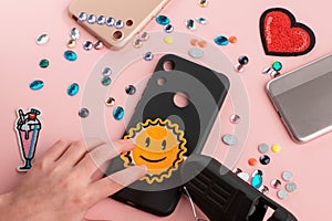 Girl putting a sun smile patch onto black phone case