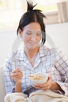 Girl in pyjama having cereal