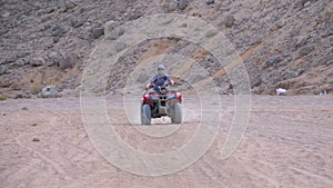 Girl on a Quad Bike Rides through the Desert of Egypt