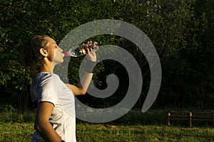 Girl quenches her thirst after playing sports outdoors