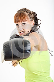 Girl in rage wearing boxing gloves ready to fight and punching o