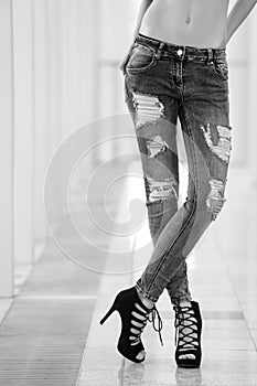Girl in ragged jeans. fashionable young girl with long legs wearing blue jeans, shoes