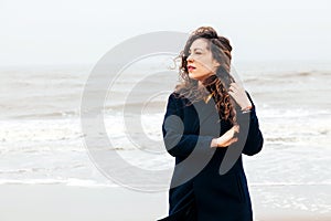 Girl rain sea wind winter portrait woman smile spring coat long hair curly mood shore snow beach